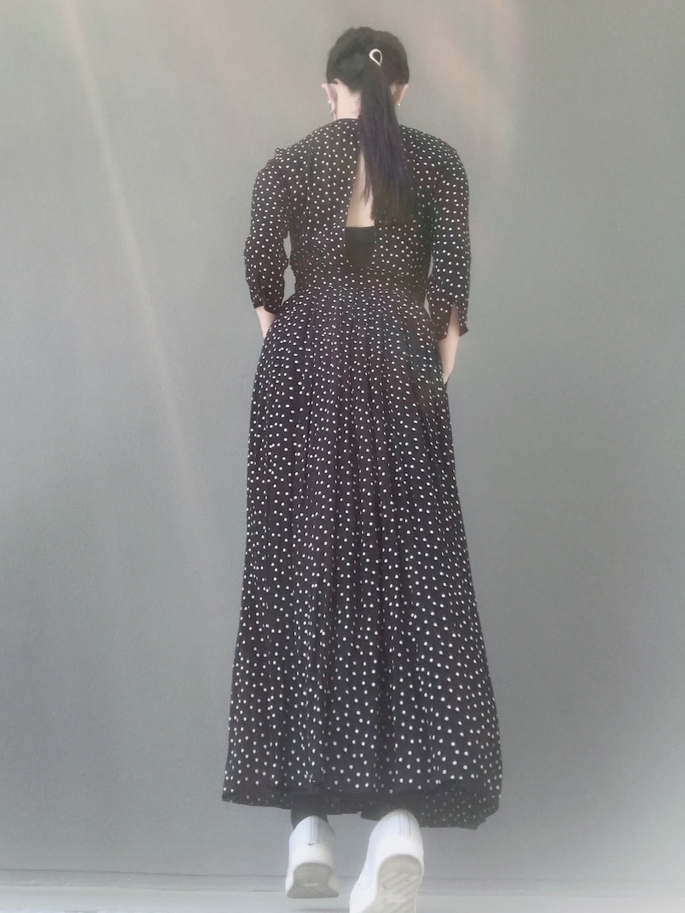 ホワイト系のスニーカー、レッド系のバッグ、ブラック系のワンピースを着用したレディースの春コーディネートの3枚目の写真