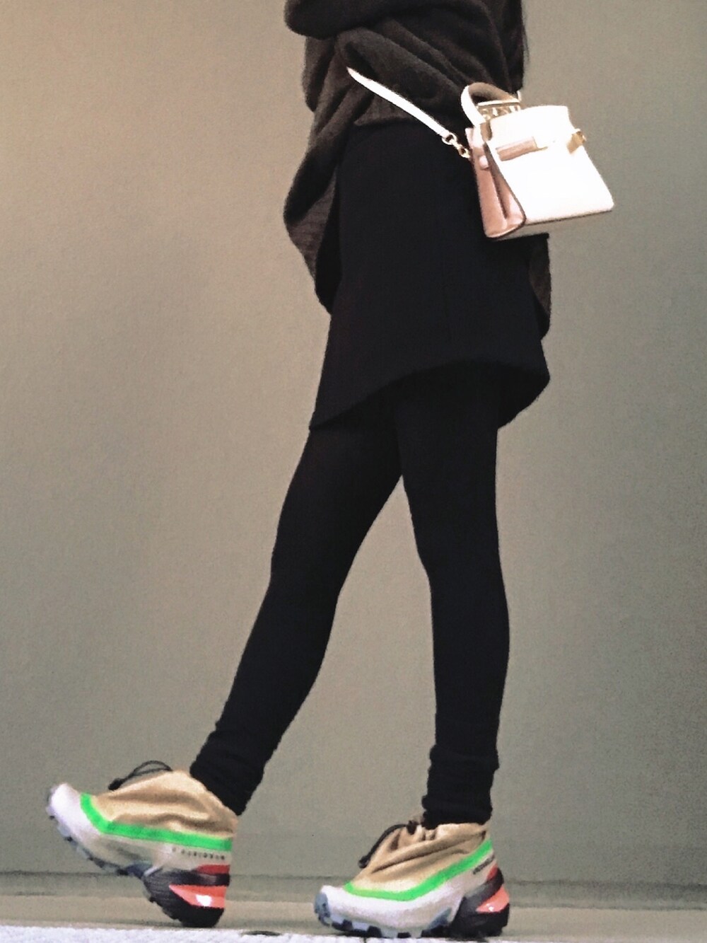 ブラック系のスカート、ベージュ系のスニーカーを着用したレディースの冬コーディネートの2枚目の写真