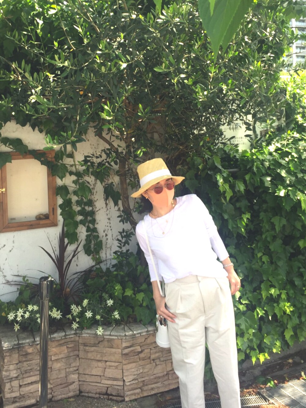 ホワイト系のTシャツ/カットソー、ベージュ系のチノパンツ、その他の帽子を着用したレディースの春コーディネートの2枚目の写真