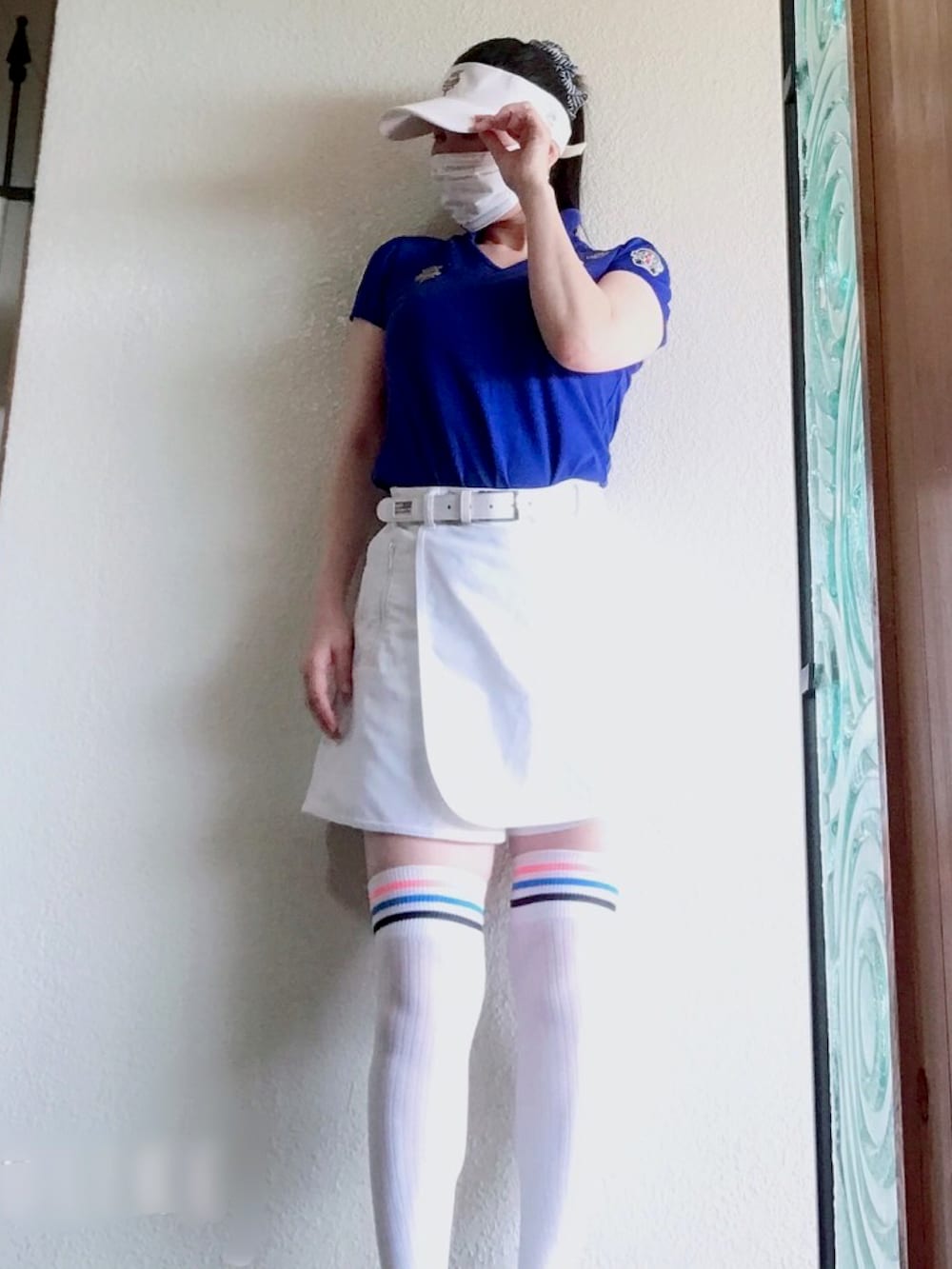 ブルー系のポロシャツ、ホワイト系のスカート、ピンク系のシューズを着用したレディースの夏コーディネートの2枚目の写真