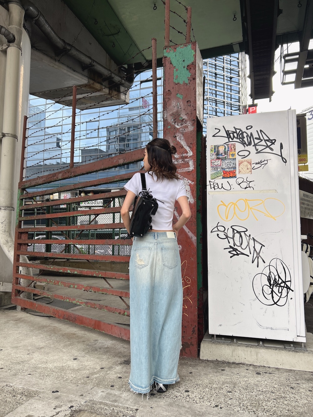 ホワイト系のTシャツ/カットソー、ブルー系のデニムスカート、ホワイト系のハンドバッグを着用したレディースの春コーディネートの3枚目の写真