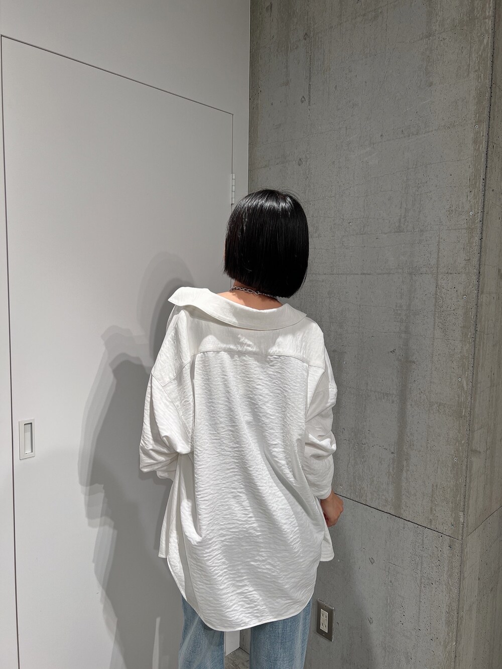 ホワイト系のシャツ/ブラウス、ブルー系のデニムパンツ、ブラック系のキャミソールを着用したレディースの冬コーディネートの4枚目の写真