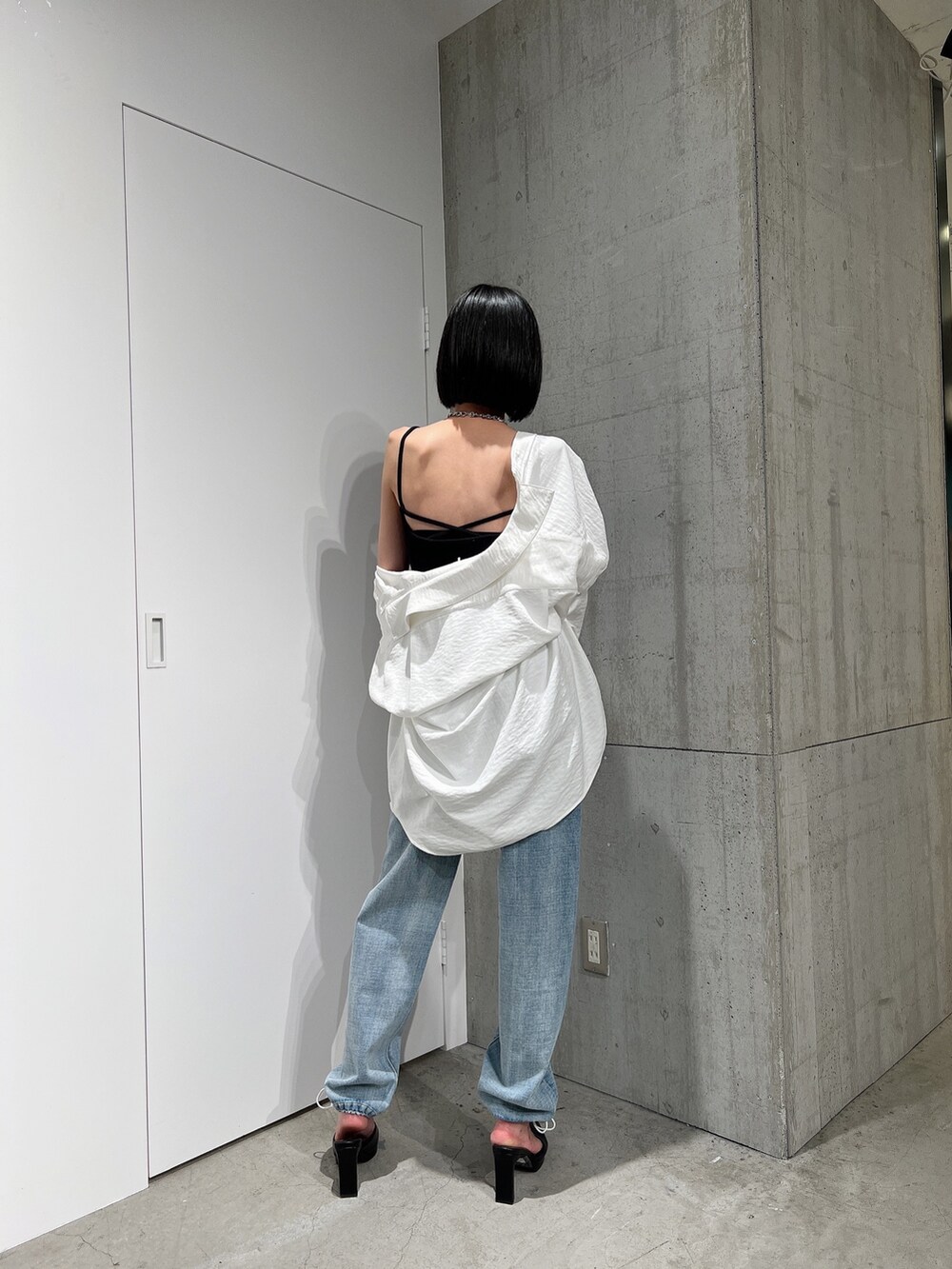 ホワイト系のシャツ/ブラウス、ブルー系のデニムパンツ、ブラック系のキャミソールを着用したレディースの冬コーディネートの2枚目の写真