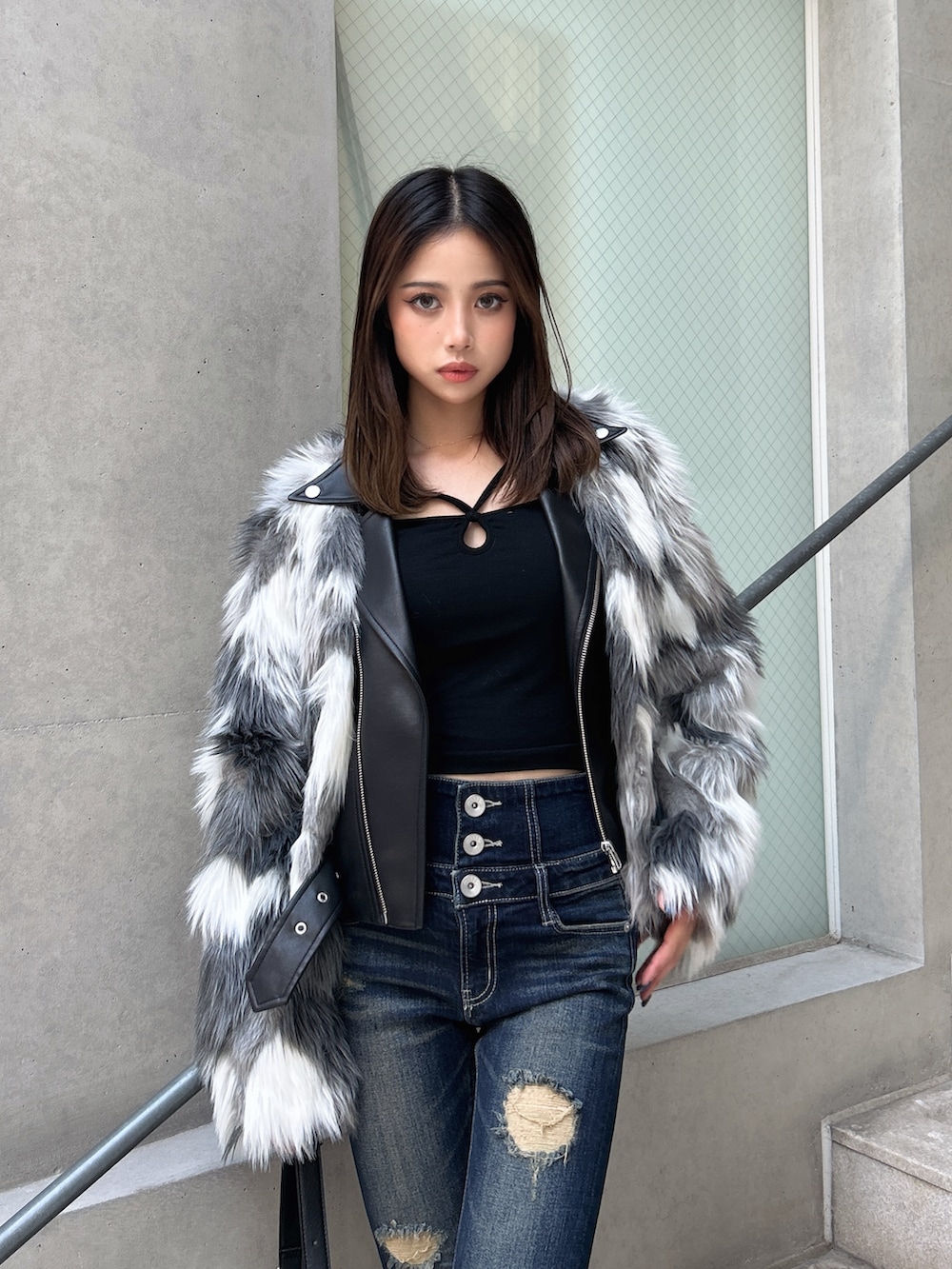 ブルー系のデニムパンツ、ブラック系のブーツ、ブラウン系のハンドバッグを着用したレディースの秋コーディネートの4枚目の写真