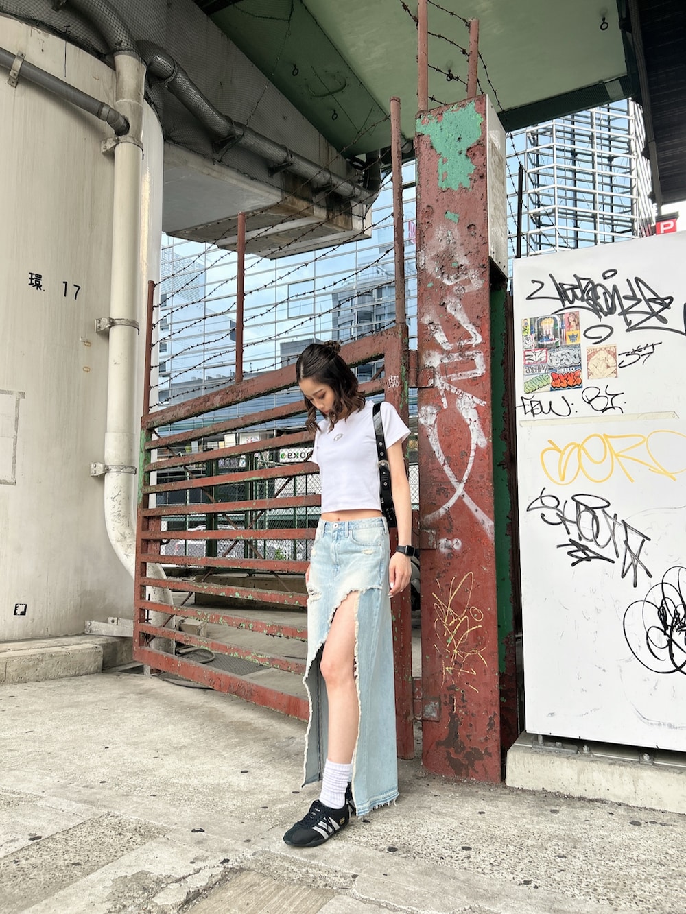 ホワイト系のTシャツ/カットソー、ブルー系のデニムスカート、ホワイト系のハンドバッグを着用したレディースの春コーディネートの2枚目の写真