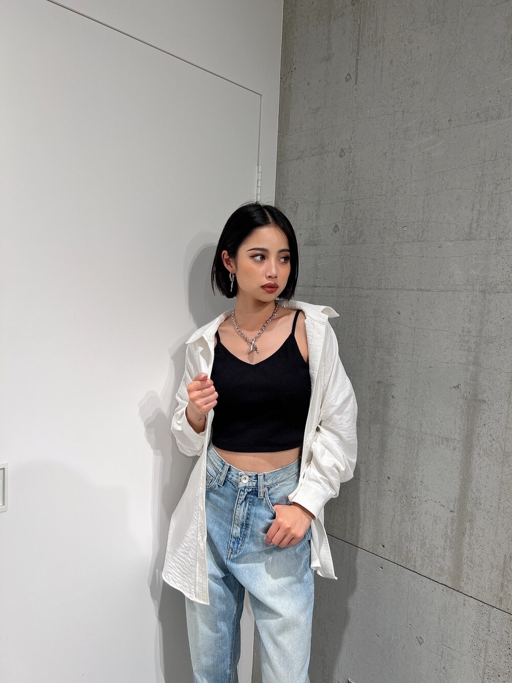 ホワイト系のシャツ/ブラウス、ブルー系のデニムパンツ、ブラック系のキャミソールを着用したレディースの冬コーディネートの3枚目の写真