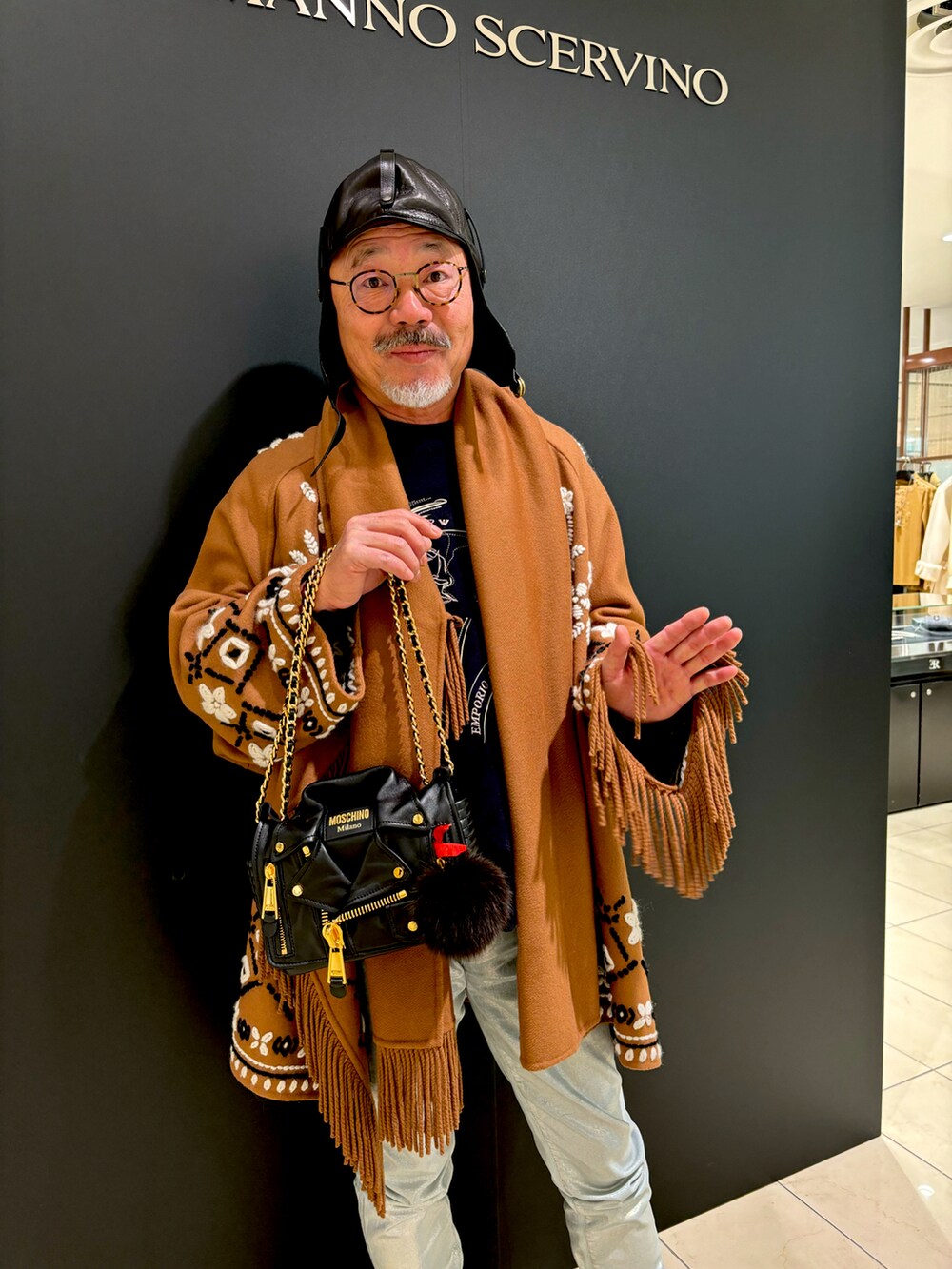 ブラウン系のその他アウター、ブラック系のショルダーバッグ、ブラック系のキャップを着用したメンズの冬コーディネートの2枚目の写真