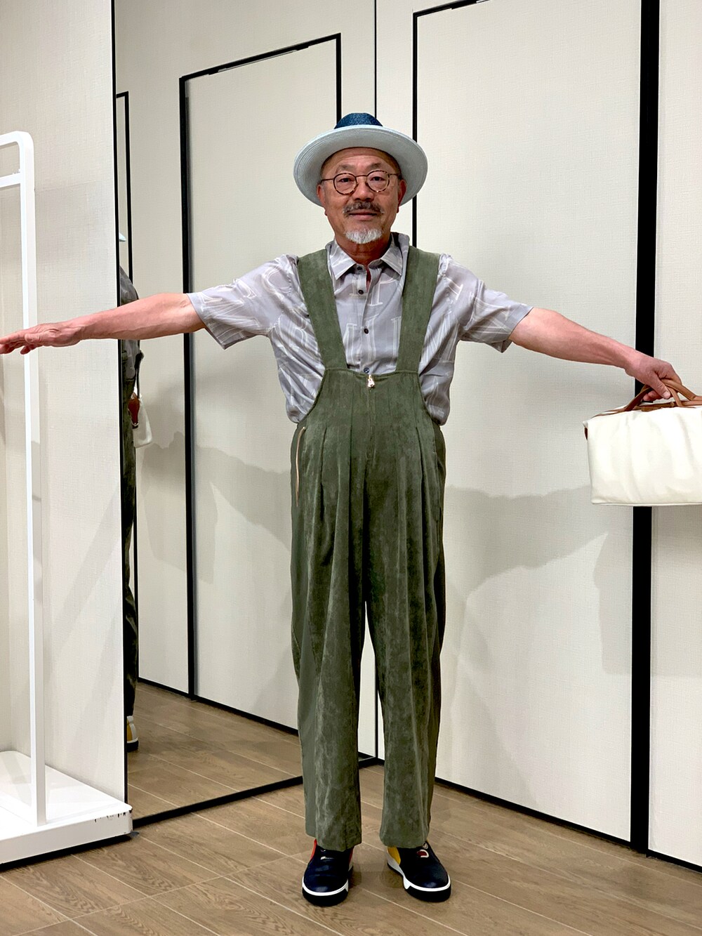 ホワイト系のバッグ、グレー系のシャツ/ブラウス、グリーン系のオールインワン・サロペットを着用したメンズの春コーディネートの2枚目の写真