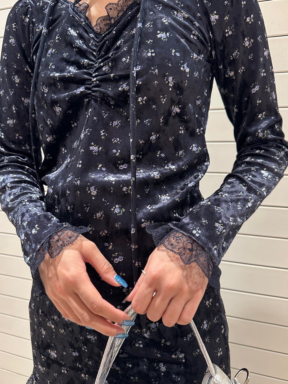 ブルー系のワンピース、シルバー系のハンドバッグ、ブラック系のデニムパンツを着用したレディースの冬コーディネートの9枚目の写真