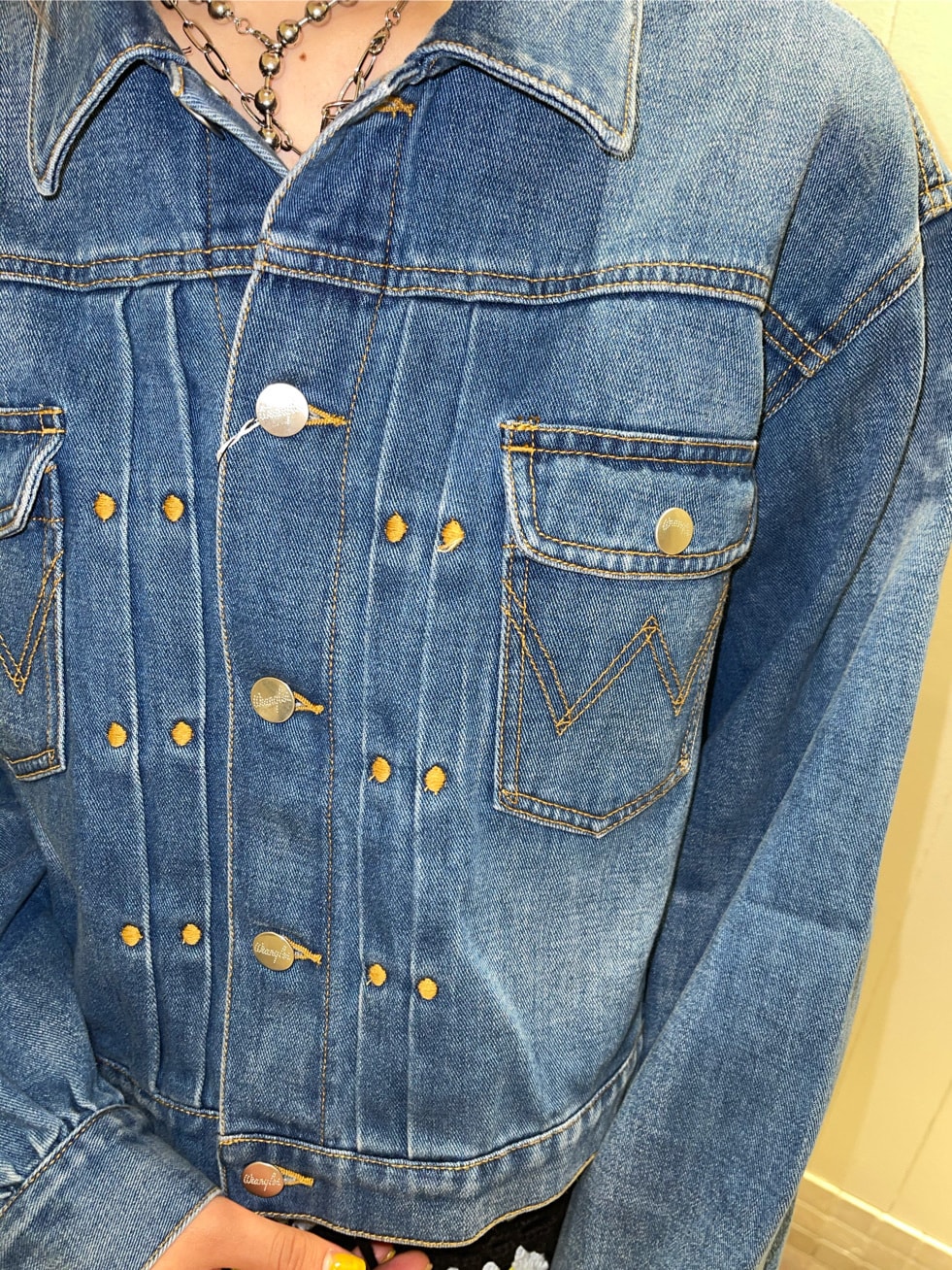 ブルー系のデニムジャケット、ブラック系のスカートを着用したレディースの春コーディネートの4枚目の写真