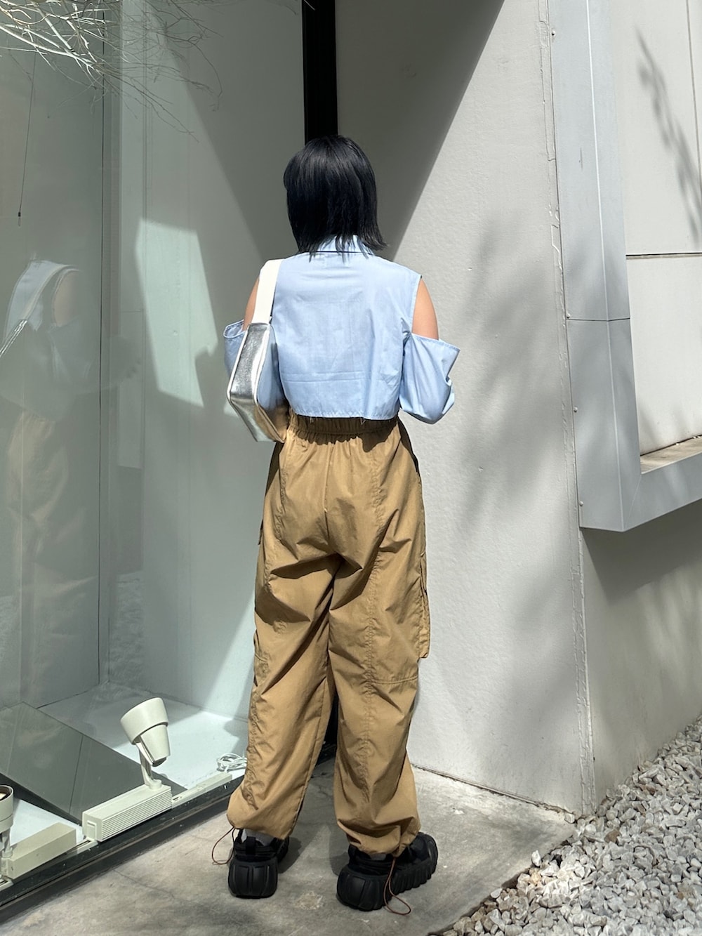ベージュ系のカーゴパンツ、ブラック系のスニーカー、シルバー系のハンドバッグを着用したレディースの春コーディネートの3枚目の写真