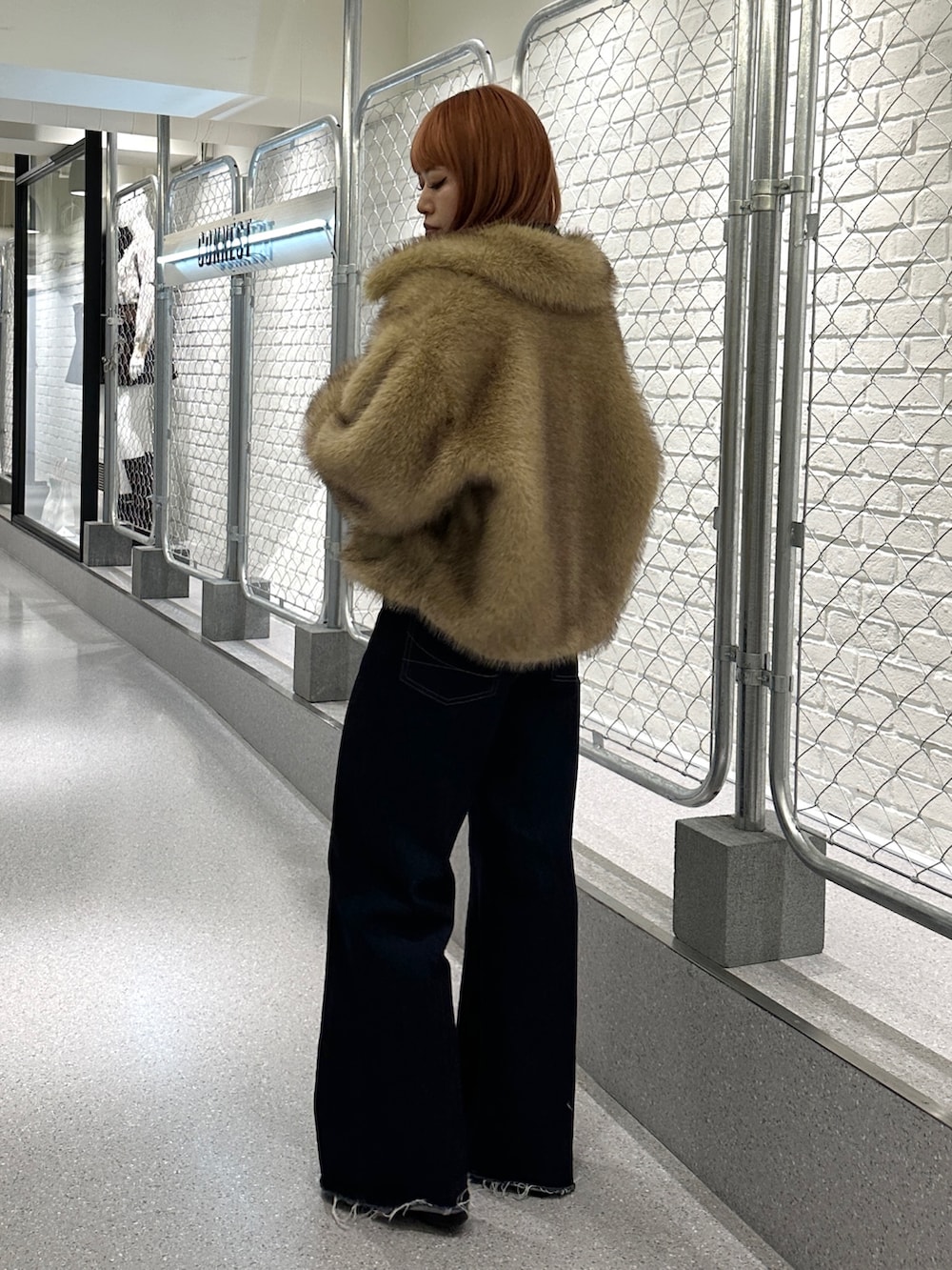 ブルー系のデニムパンツ、ブラック系のパンプス、ブラック系のニット/セーターを着用したレディースの秋コーディネートの2枚目の写真