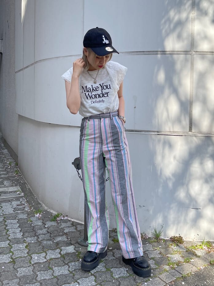 ブラック系のその他シューズ、ブラック系のスラックス、ホワイト系のTシャツ/カットソーを着用したレディースの春コーディネートの2枚目の写真