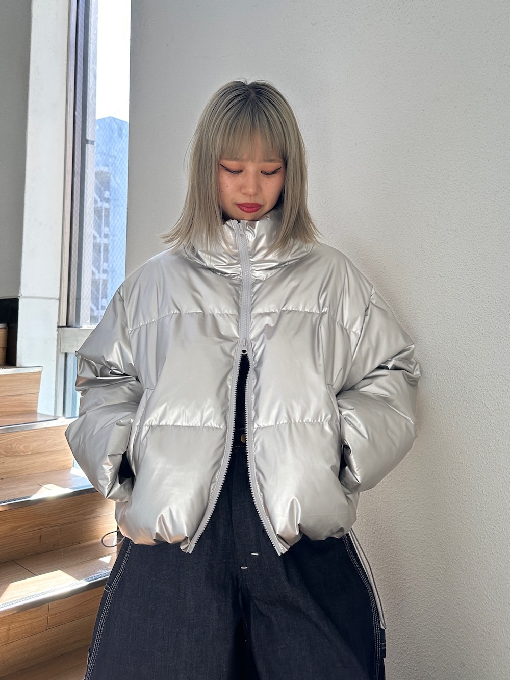 シルバー系のダウンジャケット/コート、ブラック系のTシャツ/カットソー、ブラック系のスニーカーを着用したレディースの秋コーディネートの6枚目の写真