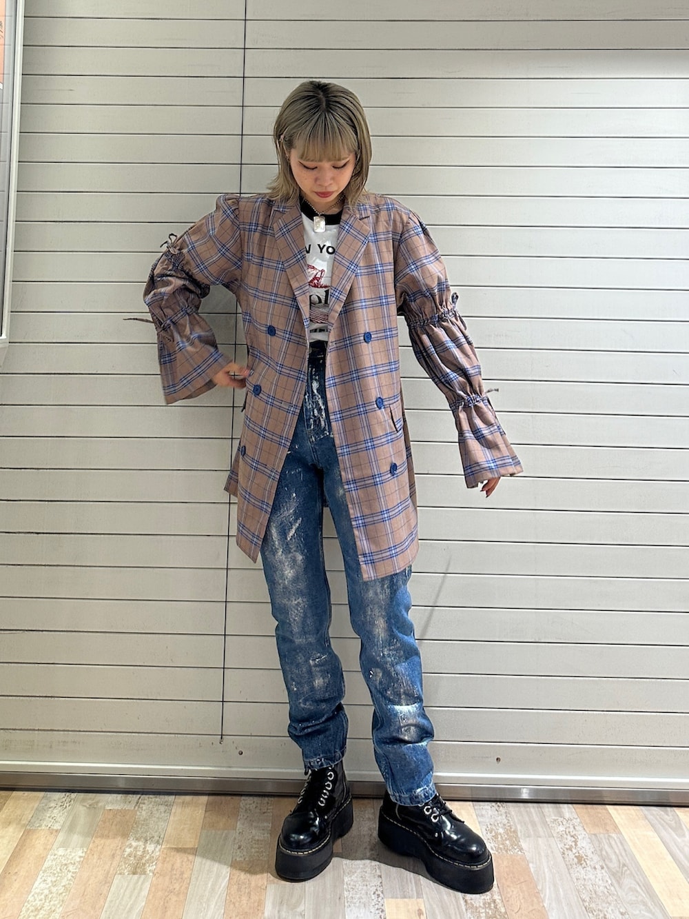 ベージュ系のワンピース、ホワイト系のTシャツ/カットソー、ブルー系のデニムパンツを着用したレディースの秋コーディネートの2枚目の写真