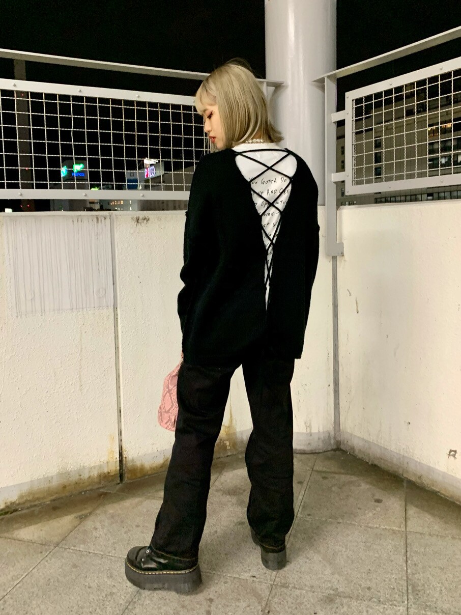 ピンク系のショルダーバッグ、ブラック系のデニムパンツ、ブラック系のニット/セーターを着用したレディースの冬コーディネートの2枚目の写真