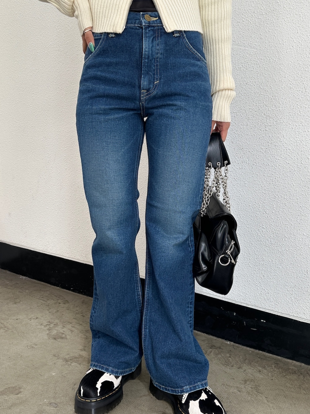 ブルー系のデニムパンツ、ホワイト系のカーディガン/ボレロ、ブラック系のTシャツ/カットソーを着用したレディースの冬コーディネートの6枚目の写真