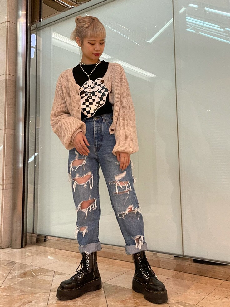 ブルー系のデニムパンツ、ホワイト系のニット/セーター、ブラック系のTシャツ/カットソーを着用したレディースの春コーディネートの2枚目の写真