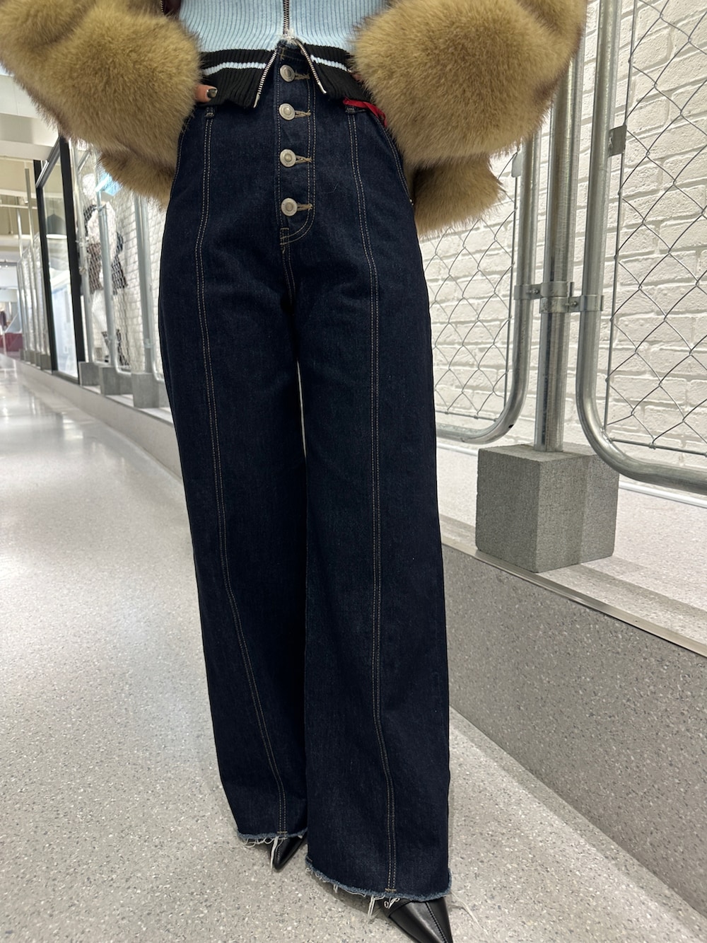 ブルー系のデニムパンツ、ブラック系のパンプス、ブラック系のニット/セーターを着用したレディースの秋コーディネートの8枚目の写真