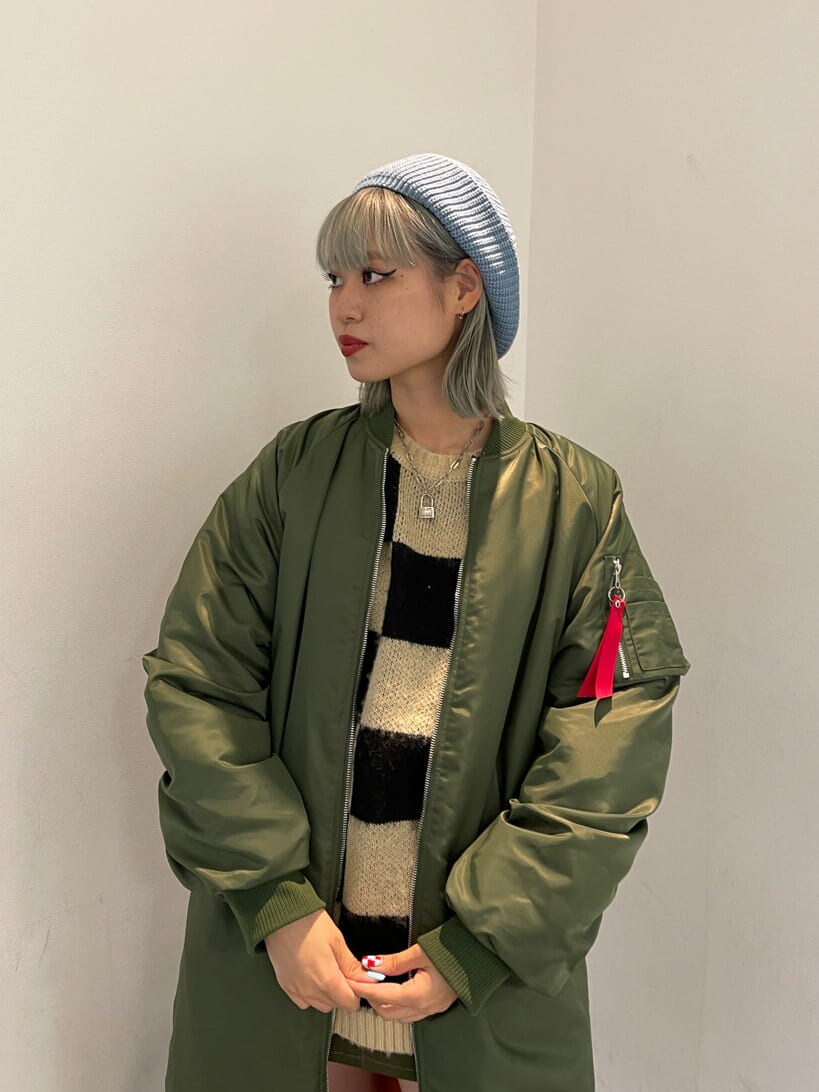 ブラック系のニット/セーター、グリーン系のMA-1、グリーン系のスカートを着用したレディースの秋コーディネートの5枚目の写真