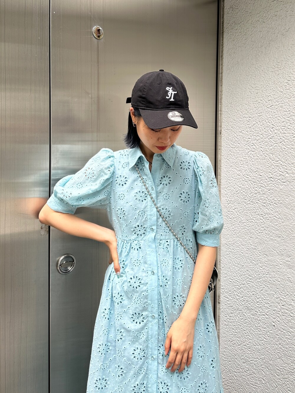 ブルー系のワンピース、ブラック系のスニーカー、ブラック系のキャップを着用したレディースの夏コーディネートの5枚目の写真