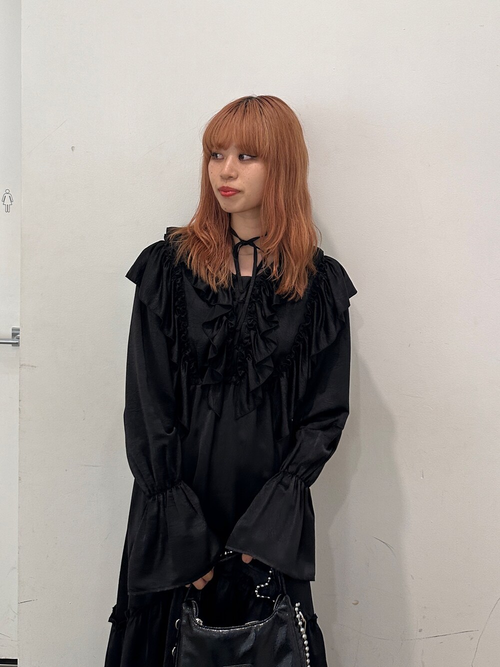 ブラック系のワンピース、ブラック系のハンドバッグ、ブラック系のブーツを着用したレディースの秋コーディネートの7枚目の写真