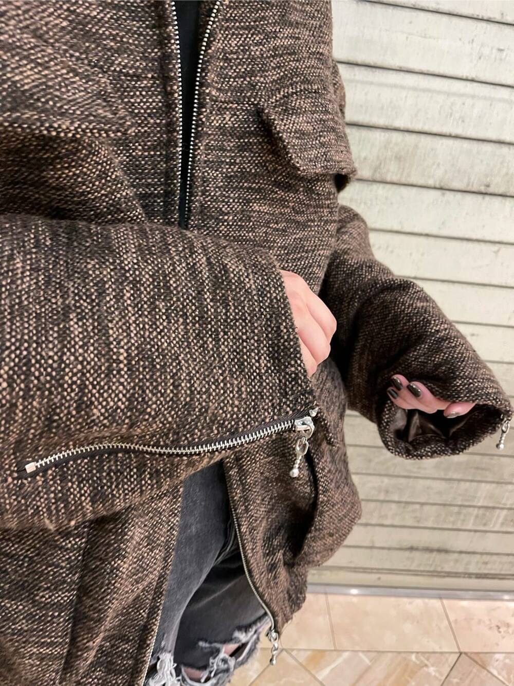 ブラック系のブーツ、ブラック系のデニムパンツ、ブラウン系のブルゾンを着用したレディースの夏コーディネートの7枚目の写真