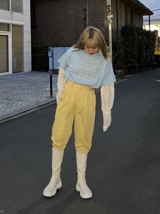 イエロー系のスラックス、ホワイト系のブーツ、ホワイト系のTシャツ/カットソーを着用したレディースの春コーディネートの2枚目の写真