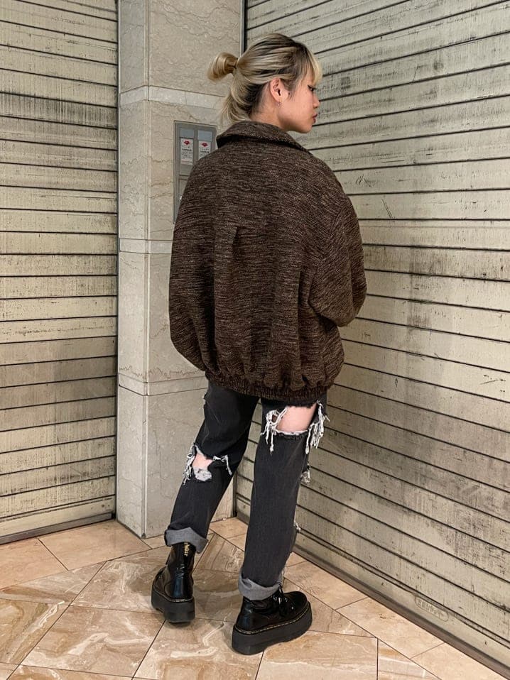 ブラック系のブーツ、ブラック系のデニムパンツ、ブラウン系のブルゾンを着用したレディースの夏コーディネートの2枚目の写真