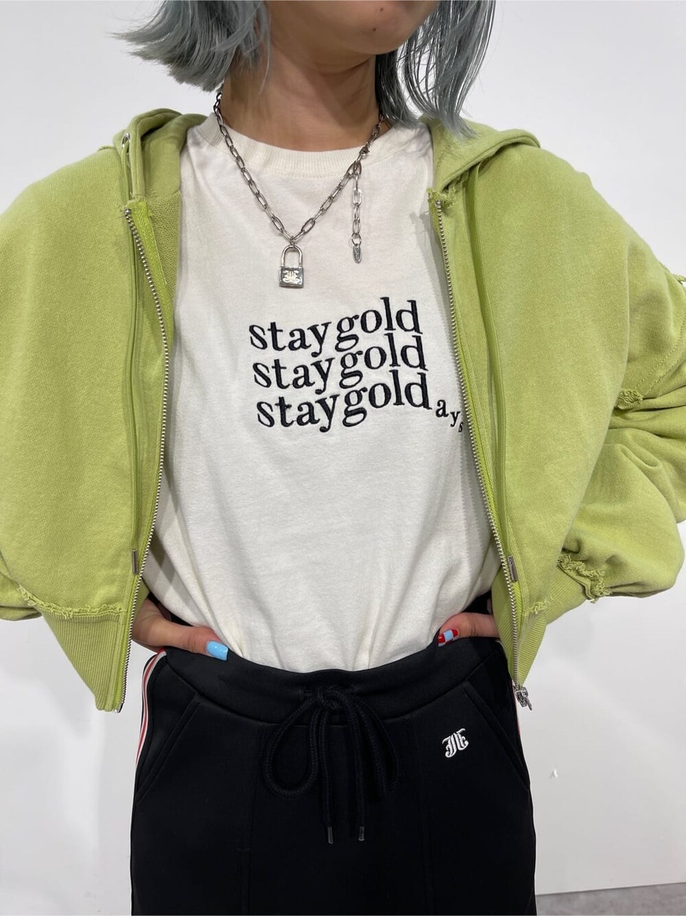 ホワイト系のTシャツ/カットソー、グリーン系のパーカー、レッド系のスカートを着用したレディースの秋コーディネートの5枚目の写真