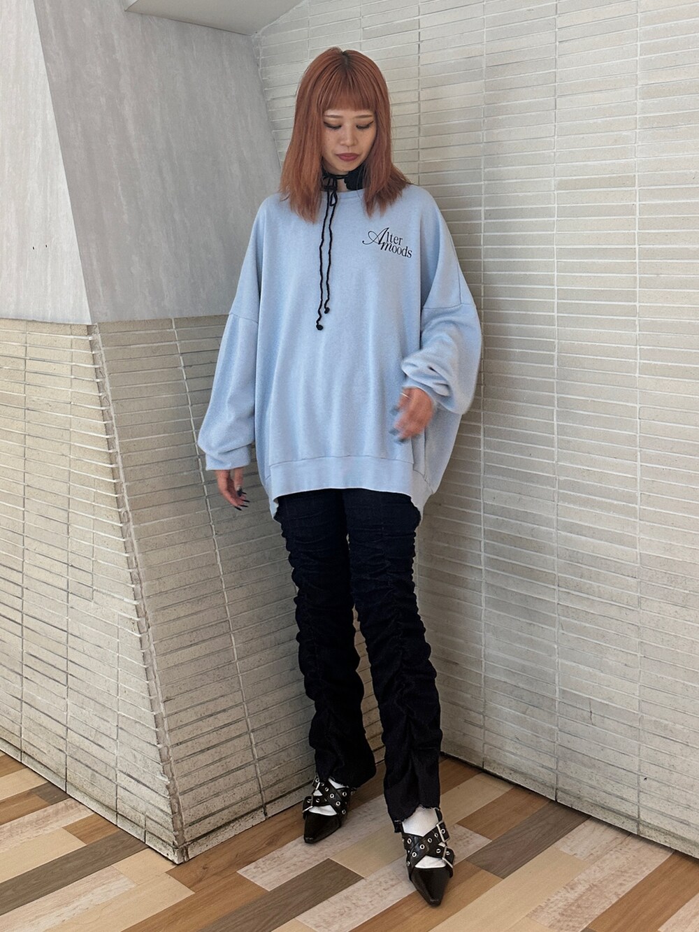 ブルー系のスウェット、ブラック系のパンプス、ブルー系のデニムパンツを着用したレディースの秋コーディネートの4枚目の写真