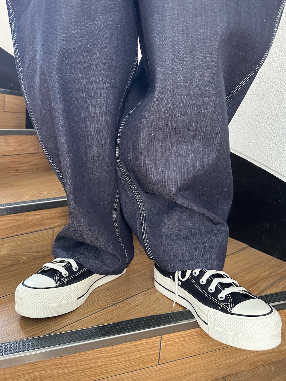 シルバー系のダウンジャケット/コート、ブラック系のTシャツ/カットソー、ブラック系のスニーカーを着用したレディースの秋コーディネートの8枚目の写真