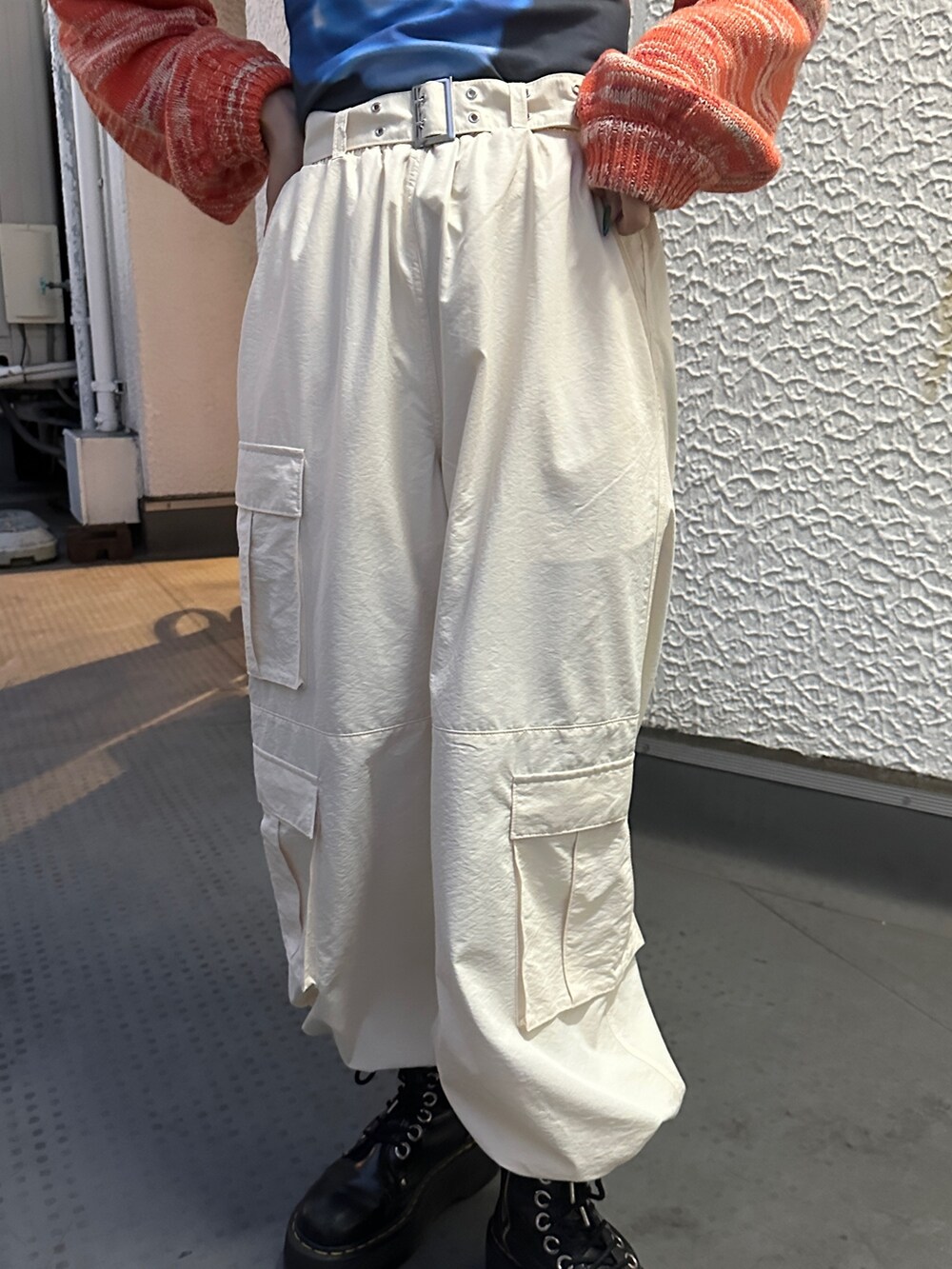 イエロー系のその他パンツ、オレンジ系のニット/セーター、ブラック系のTシャツ/カットソーを着用したレディースの冬コーディネートの9枚目の写真