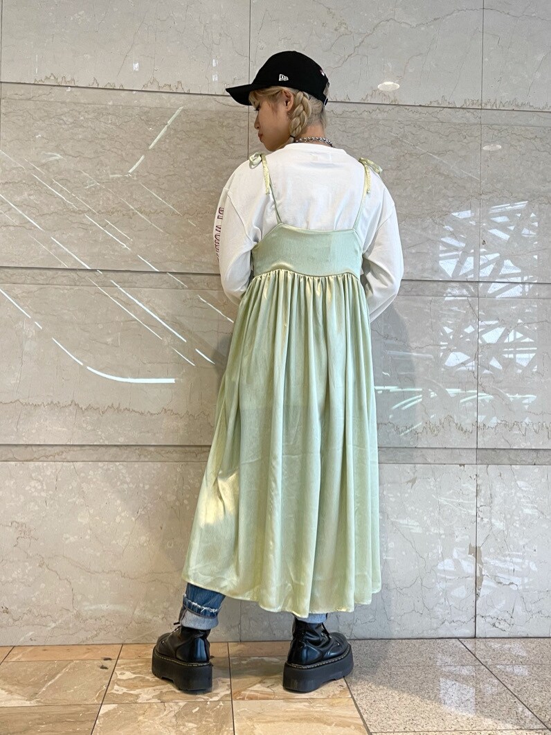 グリーン系のワンピース、ホワイト系のTシャツ/カットソー、ブルー系のデニムパンツを着用したレディースの春コーディネートの2枚目の写真