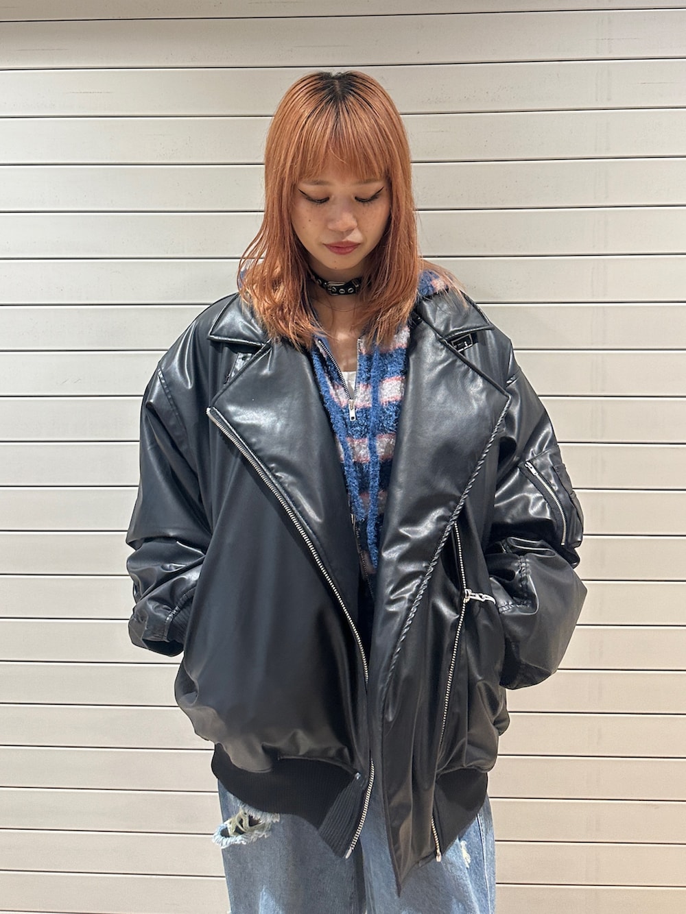 ブラック系のブルゾン、ブルー系のパーカー、ブルー系のデニムパンツを着用したレディースの秋コーディネートの6枚目の写真