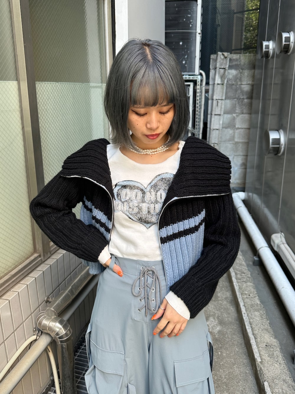 グレー系のその他パンツ、ホワイト系のTシャツ/カットソー、ブラック系のニット/セーターを着用したレディースの秋コーディネートの6枚目の写真