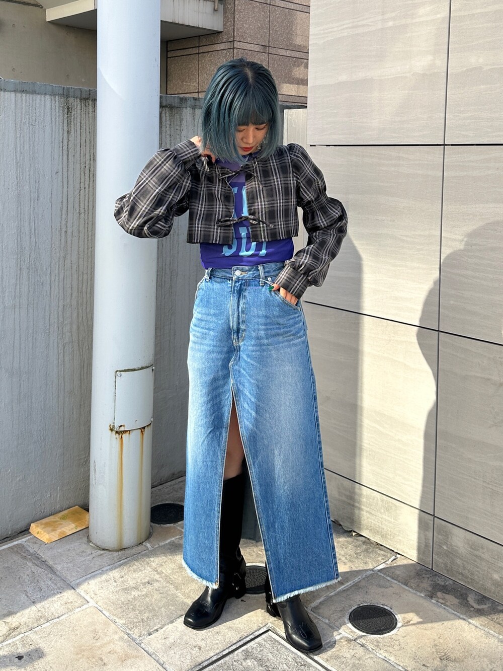 ブルー系のスカート、パープル系のTシャツ/カットソー、ブラック系のワンピースを着用したレディースの冬コーディネートの2枚目の写真