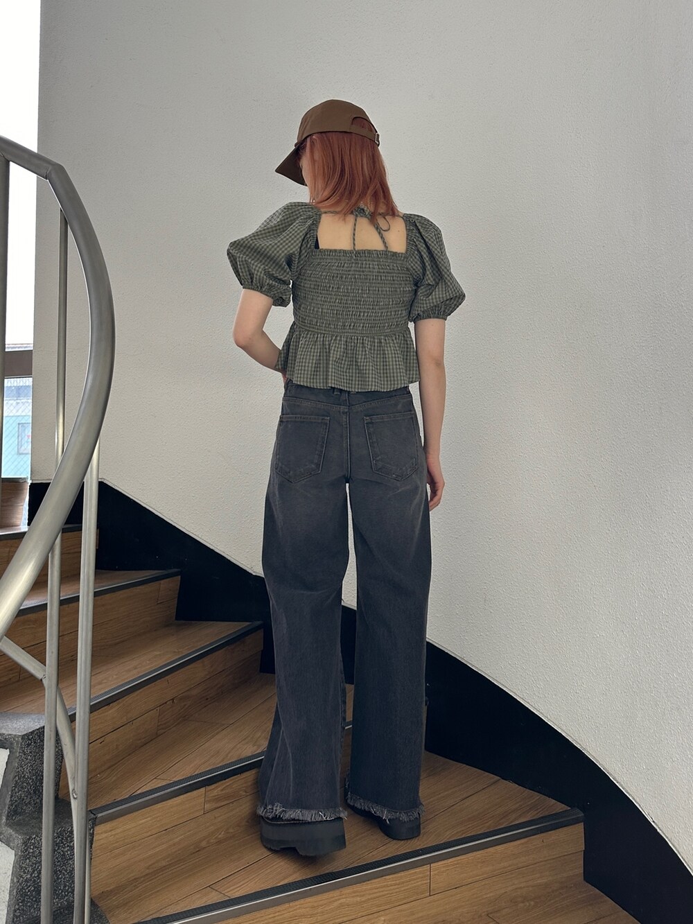 ブラック系のデニムパンツ、グリーン系のシャツ/ブラウス、ブラック系のブーツを着用したレディースの冬コーディネートの3枚目の写真