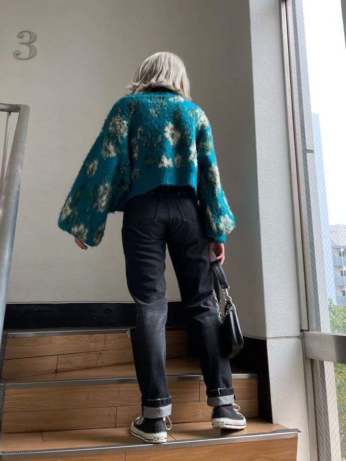 ブラック系のデニムパンツ、ブルー系のカーディガン/ボレロ、ブラック系のシャツ/ブラウスを着用したレディースの秋コーディネートの5枚目の写真