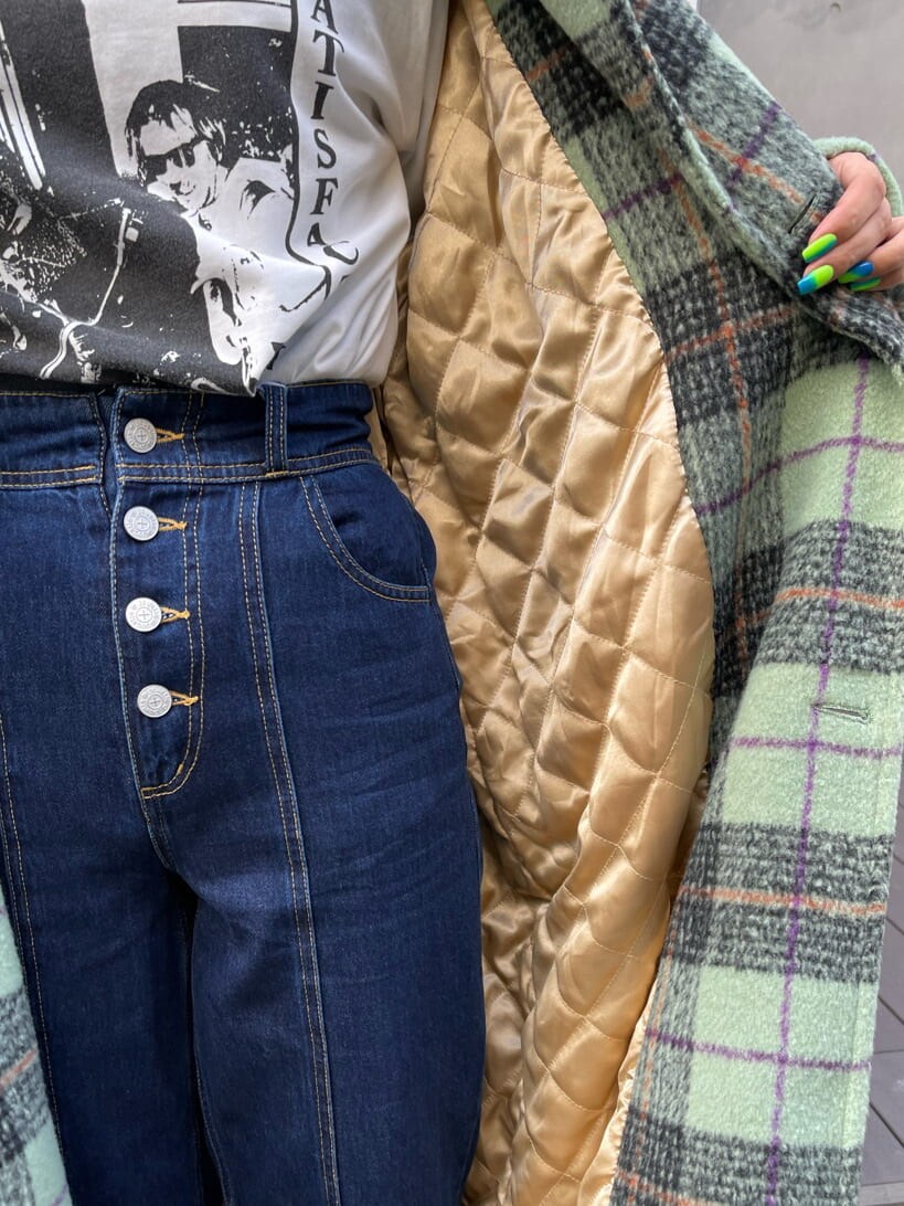 グリーン系のチェスターコート、ブラック系のブーツ、ブルー系のデニムパンツを着用したレディースの秋コーディネートの7枚目の写真