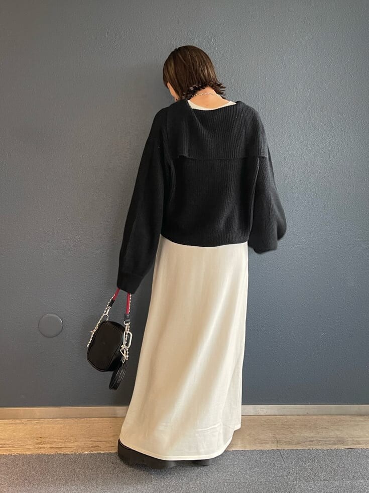 ブラック系のショルダーバッグ、ホワイト系のワンピース、ブラック系のニット/セーターを着用したレディースの秋コーディネートの4枚目の写真