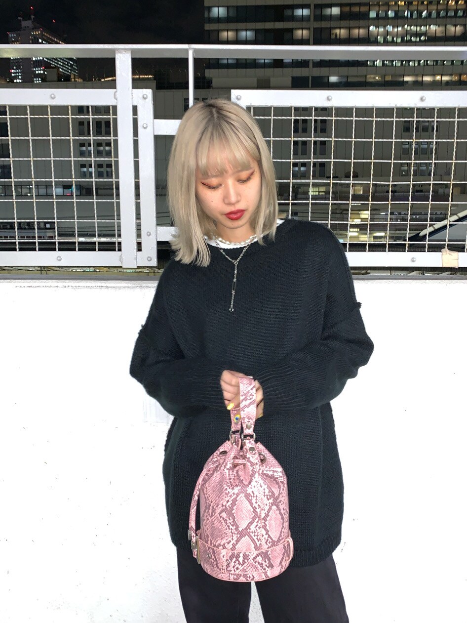 ピンク系のショルダーバッグ、ブラック系のデニムパンツ、ブラック系のニット/セーターを着用したレディースの冬コーディネートの3枚目の写真