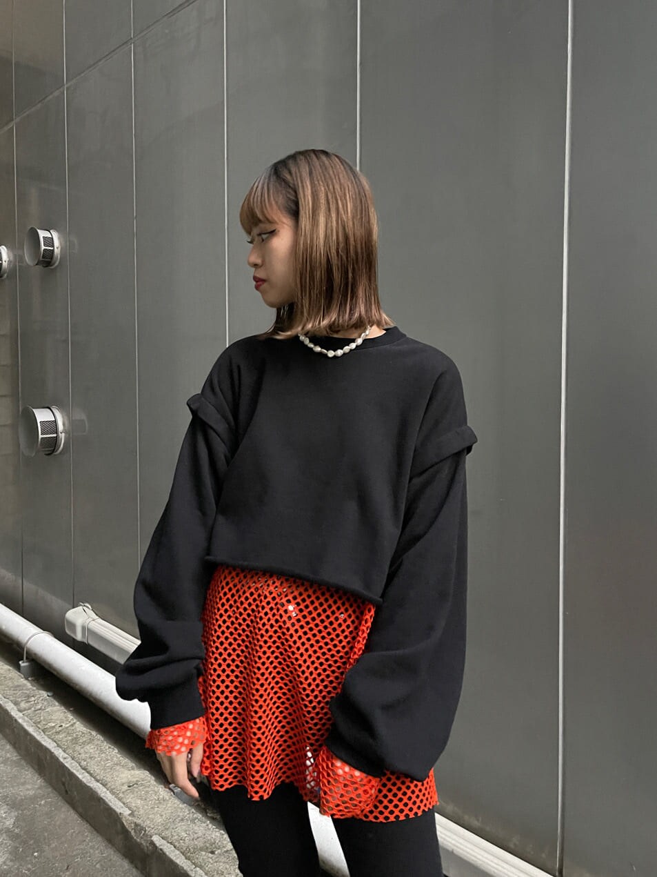 ブラック系のブーツ、ブラック系のTシャツ/カットソー、オレンジ系のTシャツ/カットソーを着用したレディースの冬コーディネートの6枚目の写真