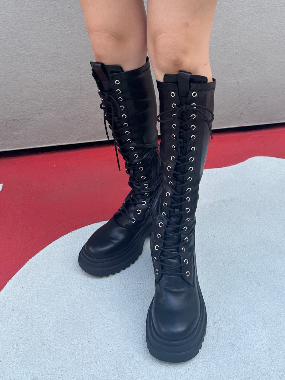 グレー系のスカート、ブラック系のブーツ、ホワイト系のTシャツ/カットソーを着用したレディースの夏コーディネートの9枚目の写真