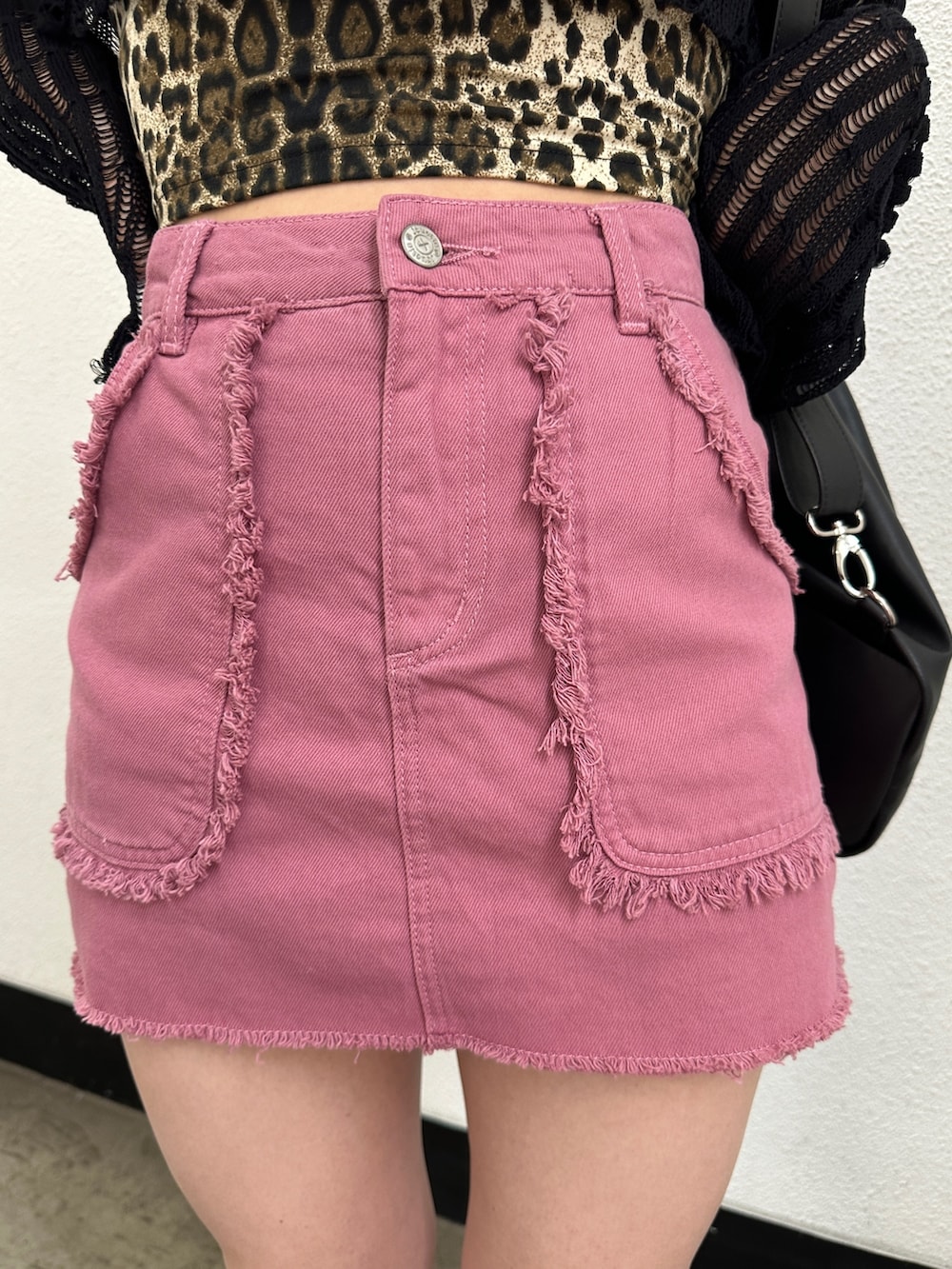 ピンク系のスカート、ブラック系のニット/セーター、ブラウン系のキャミソールを着用したレディースの冬コーディネートの9枚目の写真