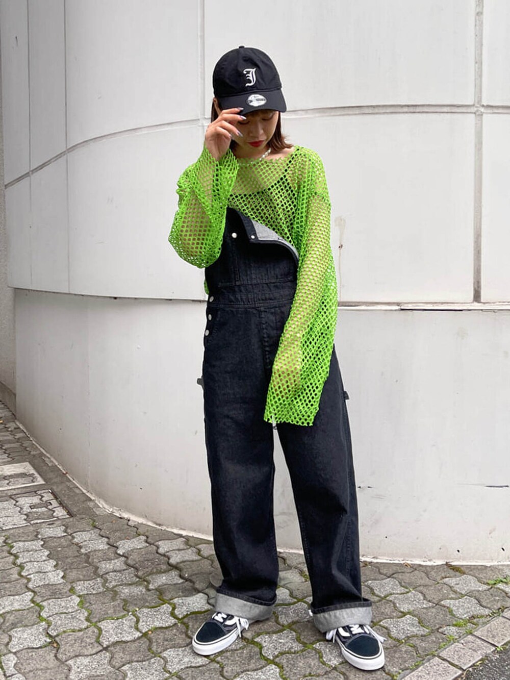 ブラック系のサロペット/オーバーオール、グリーン系のTシャツ/カットソー、ブラック系のキャップを着用したレディースの冬コーディネートの2枚目の写真