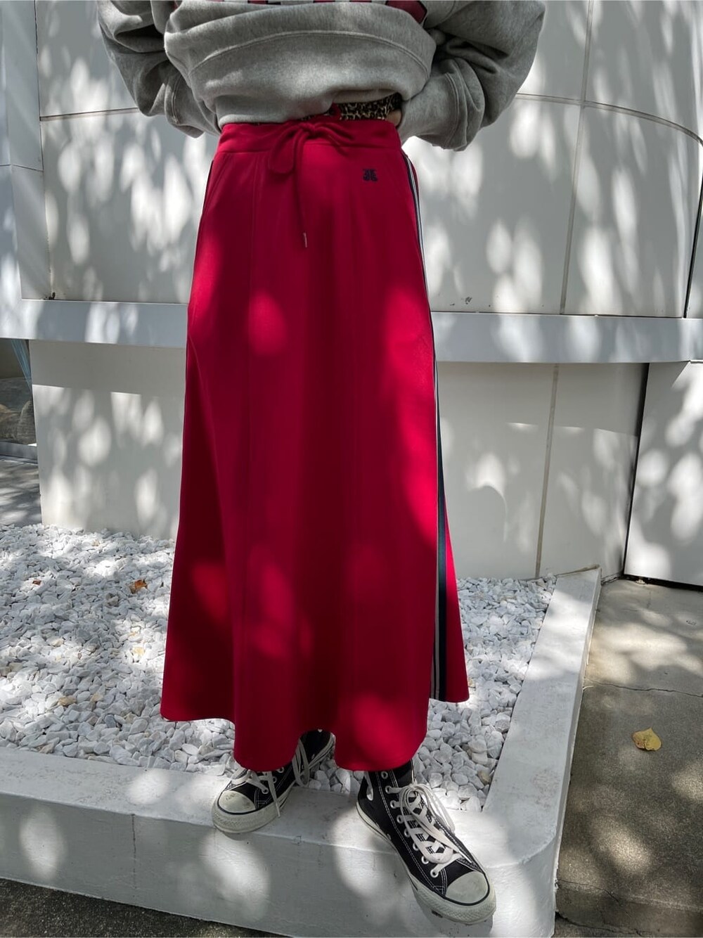 レッド系のスカート、グレー系のスウェット、ブラック系のハンチング/ベレー帽を着用したレディースの秋コーディネートの8枚目の写真