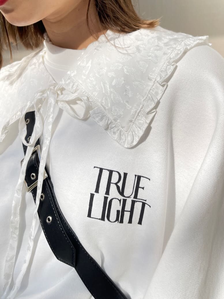 ピンク系のスラックス、ブラック系のショルダーバッグ、ホワイト系のスウェットを着用したレディースの冬コーディネートの6枚目の写真