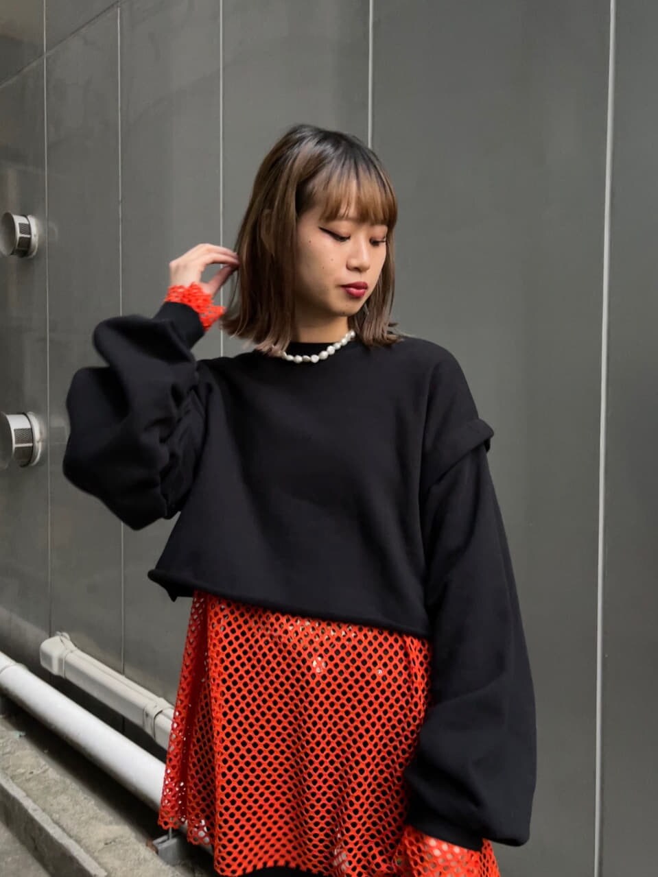 ブラック系のブーツ、ブラック系のTシャツ/カットソー、オレンジ系のTシャツ/カットソーを着用したレディースの冬コーディネートの5枚目の写真