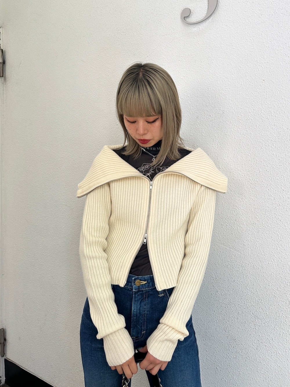 ブルー系のデニムパンツ、ホワイト系のカーディガン/ボレロ、ブラック系のTシャツ/カットソーを着用したレディースの冬コーディネートの3枚目の写真